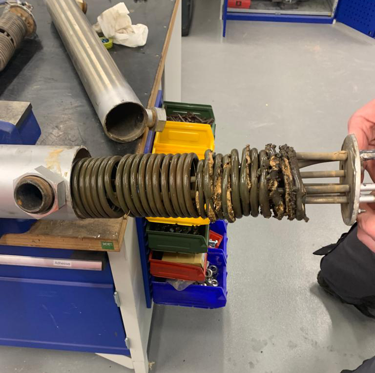L'immagine mostra un riscaldatore elettrico scoppiato, durante intervento di manutenzione su un termoregolatore 