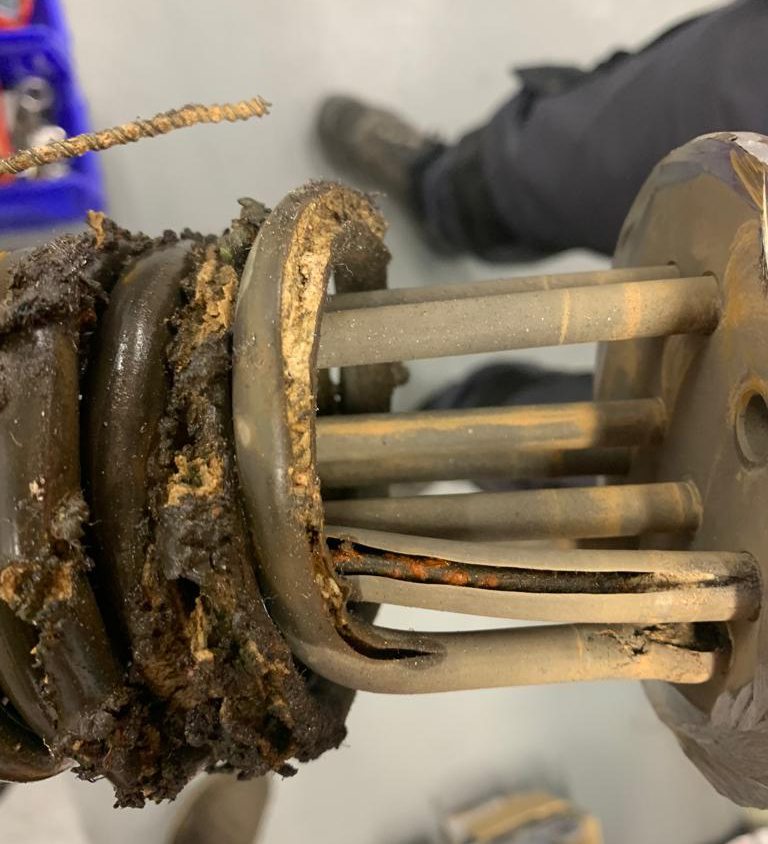 L'immagine mostra il dettaglio di un riscaldatore elettrico scoppiato, durante intervento di manutenzione su un termoregolatore 